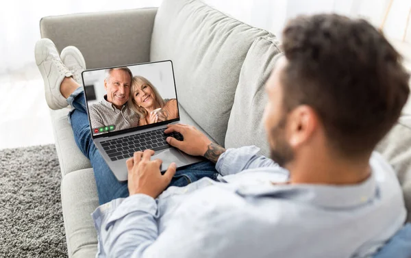 Man Making Video Call On Laptop With Senior Parents While Relaxing On Couch At Home, Young Male Having Virtual Meeting With His Elderly Mom And Dad, Enjoying Online Communication, Collage