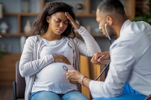 Pregnant Millennial Black Woman Suffering Migraine Sitting Chair Clinic Touching — Foto de Stock