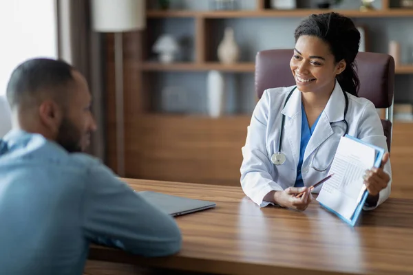 Friendly Pretty Black Lady Doctor Consulting Sick Middle Eastern Young — Fotografia de Stock