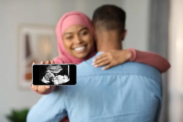 Будьте Батьками Happy Black Islamic Lady Showing Smartphone Baby Ultrasound — стокове фото