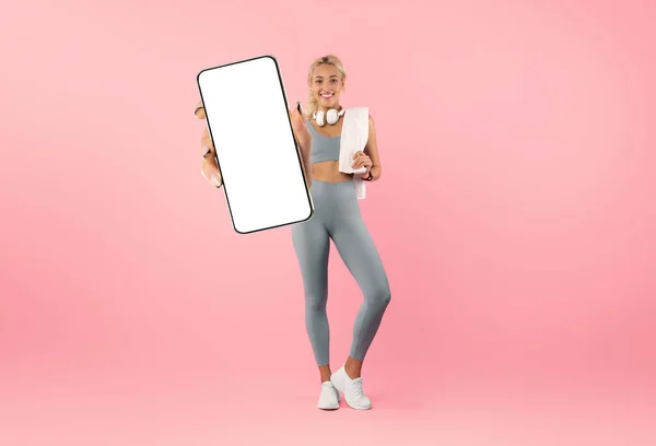 Online Fitness. Sporty Young Woman Demonstrating Big Blank Smartphone With White Screen At Camera, Smiling Athletic Female In Sportswear Recommending Mobile App With Workouts, Collage, Mockup