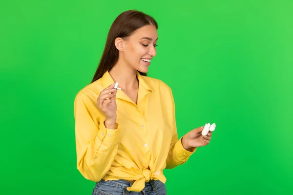 Mujer Feliz Sosteniendo Auriculares Escuchando Música Pie Sobre Fondo Verde — Foto de Stock