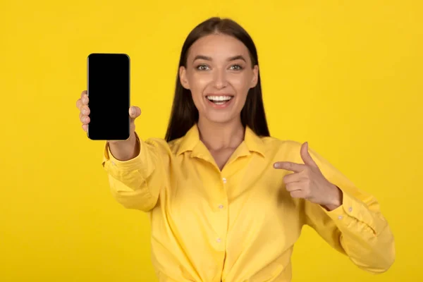 Happy Woman Showing Smartphone Pointing Finger Empty Screen Advertising Great — Stock Fotó