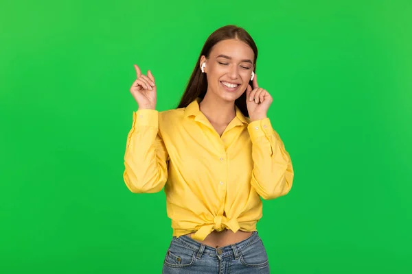 Happy Female Earbuds Listening Music Posing Standing Eyes Closed Green — Stockfoto