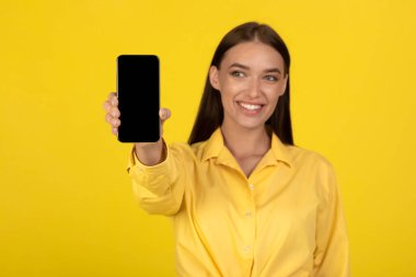 Pozitif Bayan Tutucu Akıllı Telefon Boş Ekran Reklamcılığı Mobil Teklif Stüdyosunda Sarı Arkaplan Üzerinde Pozisyon Gösteriyor. Teknoloji ve Gadget 'lar, mobil iletişim. Mockup, Seçici Odaklanma