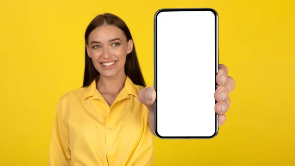 Happy Woman Showing Phone Blank Screen Smiling Camera Standing Yellow — Stockfoto