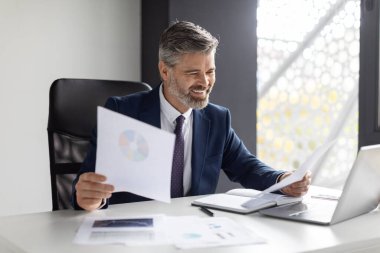 Modern Ofiste Belgelerle Çalışan Başarılı Olgun İşadamının Portresi, Takım Elbiseli Gülümseyen Orta yaşlı Girişimci Masada Oturuyor ve İşyerindeki Mali Raporları Kontrol Ediyor, Boşluğu Kopyaladı