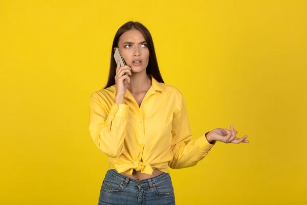 Displeased Millennial Woman Talking Mobile Phone Communicating Standing Yellow Studio — Stockfoto