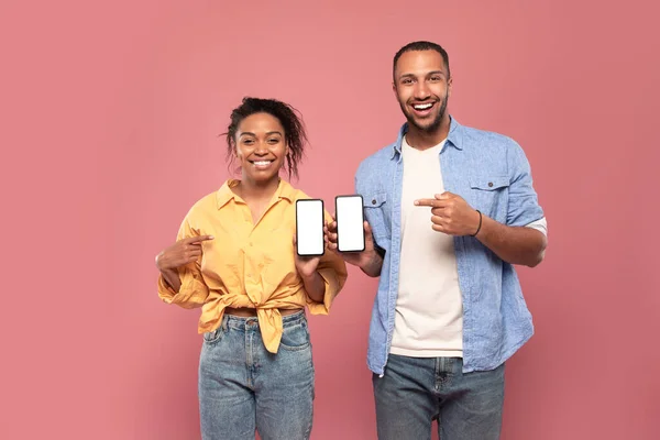 Use New Application Happy Black Couple Holding Smartphones Hands Pointing — ストック写真