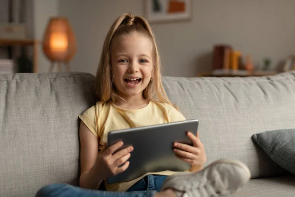 Joyful Little Girl Laughing Using Digital Tablet Smiling Camera Sitting — 图库照片