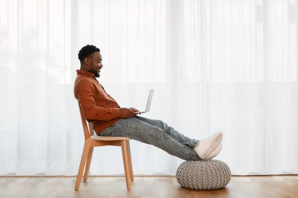 Cheerful African American Guy Using Laptop Sitting Chair Window Home — Foto de Stock