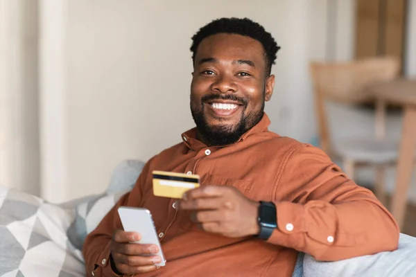 Black Guy Shopping Online Using Mobile Phone Credit Card Sitting — Stockfoto