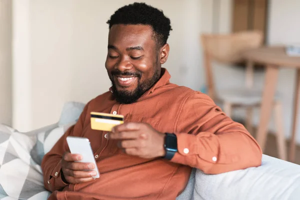 Cheerful African American Guy Shopping Online Using Cellphone Credit Card — Stock Photo, Image
