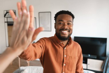 Neşeli Afrikalı Afrikalı Amerikalı Milenyum Adamı, kameraya gülümseyen, açık kapılar ardında dikilirken beşlik çakıyor. Başarılı Emlak Anlaşması Konsepti. Seçici Odaklanma