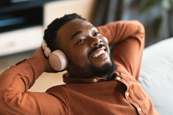 Cheerful Black Guy Wearing Headphones Listening Music Online Relaxing Sitting — Stockfoto
