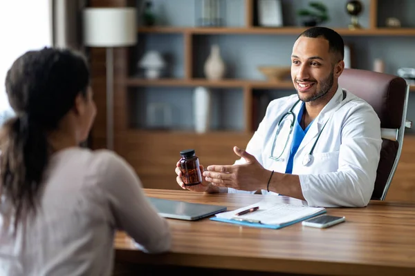 Handsome Young Arab Doctor Holding Jar Drugs While Having Conversation — Stock Fotó