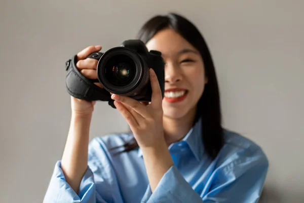 Photography Career. Happy Asian Woman Holding Camera Smiling To Camera Taking Photo Standing Indoors. Female Photographer Posing With Photocamera. Creative Hobby Concept