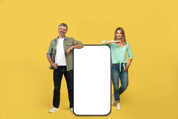 Happy Middle Aged Couple Leaning Giant Smartphone Blank Screen Mockup — Φωτογραφία Αρχείου