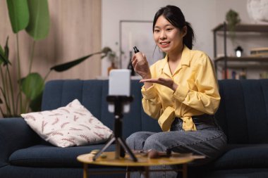 Japon Güzellik Blogcusu Makyaj Yapan Kadın Makyaj Vakfı Evdeki Kanepede Oturan Online Blog için Smartphone 'da video çekiyor. Profesyonel Blogculuk