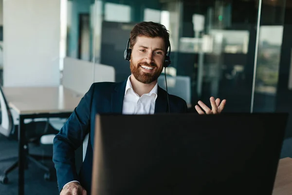 Positive Entrepreneur Beard Suit Wearing Headphones Gesticulating Computer Webcamera Office — Stockfoto