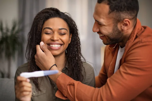 Joyful Black Couple Holding Pregnancy Test Sitting Sofa Home Husband — ストック写真