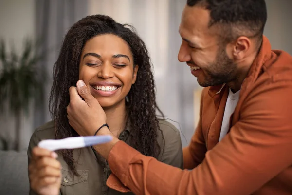 Joyful Black Couple Holding Pregnancy Test Sitting Sofa Home Husband — Foto de Stock