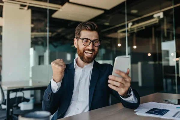 Overjoyed Businessman Suit Looking Smartphone Clenching Fists Making Victory Gesture — Foto de Stock