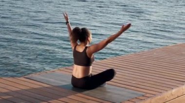 Kaynak doldurma kavramı. Genç, sakin, Afro-Amerikan kadın sporcu dışarıda meditasyon yapıyor. Nilüfer pozisyonunda, göl kenarında oturuyor. Doğanın tadını çıkarıyor.