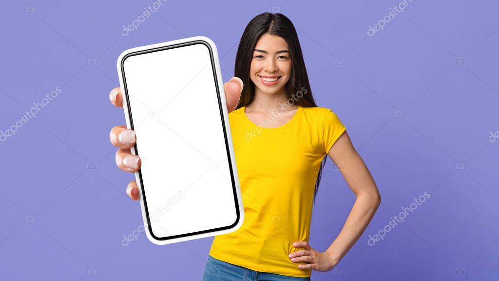 Great Mobile App. Happy Young Korean Woman Holding Smartphone With Blank White Screen, Standing Over Purple Studio Background With Free Space, Mockup, Collage, Panorama