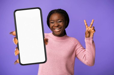 Stüdyoda Mor Arkaplan Üzerinde Beyaz Boş Ekran Gösterirken V-Sing ve Gülerken Neşeli Siyah Kadın Mobil Uygulama, Kolaj, Mobil Uygulama, Mobil Uygulama ve Uygulamayı Öneriyor