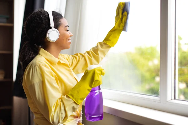 African American Millennial Woman Cleaning Window Glass Using Detergent Spray — Foto Stock