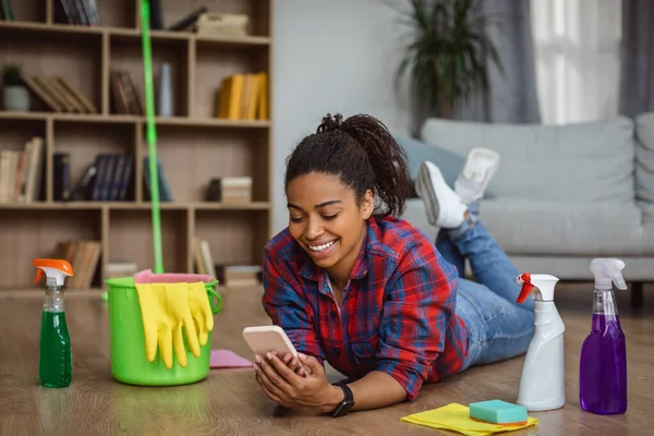 Sorrindo Milenar Afro Americana Dona Casa Com Suprimentos Limpeza Deitado — Fotografia de Stock