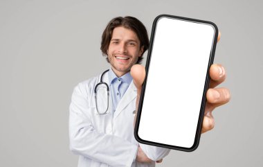 Tıbbi önlüklü pozitif erkek doktor, COVID-19 salgını, kolaj, taklit, kopyalama alanı süresince başarılı bir tedavi ve çevrimiçi danışma garantisi veren boş ekranlı cep telefonu gösteriyor.
