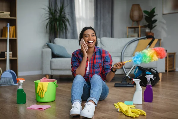 Fröhliche Afrikanisch Amerikanische Hausfrau Ruft Smartphone Und Sitzt Mit Putzutensilien — Stockfoto