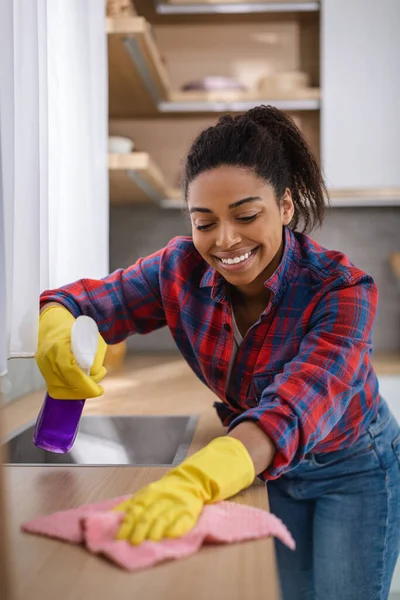 Lächelnde Afrikanisch Amerikanische Hausfrau Gummihandschuhen Mit Spray Und Lappen Wischt — Stockfoto