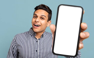 Çekici İspanyol Adam Mavi Stüdyo Arkaplanı Üzerinde Beyaz Beyaz Ekran ile Yeni Cep Telefonu Gösteriyor, Güzel Çevrimiçi Teklif veya Mobil Uygulama, Mobil Uygulama, Kolaj Öneriyor