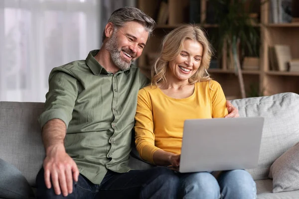 Online Pastime Smiling Middle Aged Spouses Using Laptop Home Together — Stockfoto