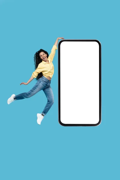 Happy Arabic Female Jumping Huge Phone Touching Empty Cellphone Screen — Foto de Stock