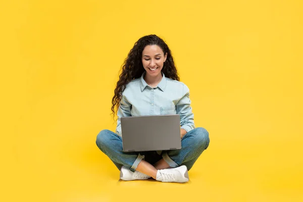 Happy Brunette Woman Using Laptop Websurfing Sitting Floor Yellow Studio — Φωτογραφία Αρχείου