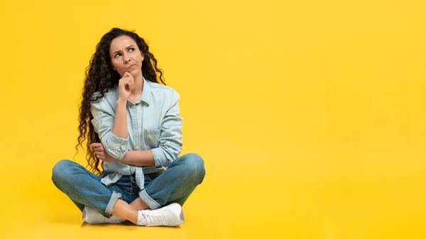 Pensive Middle Eastern Female Thinking Looking Aside Sitting Yellow Background — Stok Foto