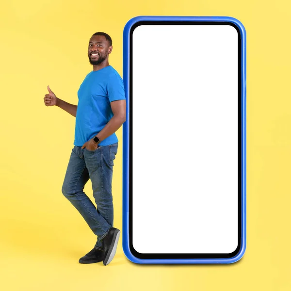 Happy African American Man Leaning Huge Cellphone Blank Screen Gesturing — 图库照片
