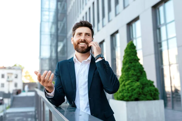 Cheerful Young European Businessman Beard Suit Calling Phone Balcony Modern — Stock Fotó
