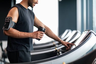 Sport Equipment. Crop Of Black Male Selecting Mode On Treadmill Before Jogging, Young Muscular African American Man Touching Control Panel, Enjoying Fitness Workout At Modern Gym, Side View