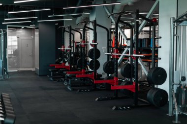 Heavy Weight Lifting Equipment Standing In A Row In Empty Gym, Modern Steel Machines With Barbells Waiting For Athletes In Sport Club, Set Of Training Tools For Bodybuilding, Copy Space