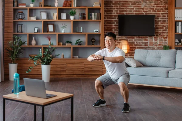 Happy Athlete Asian Mature Man Sports Clothes Squatting Living Room — Foto de Stock