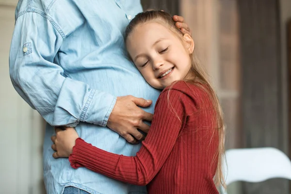 Happy Little Girl Embracing Mothers Pregnant Belly Smiling Closed Eyes — Foto de Stock