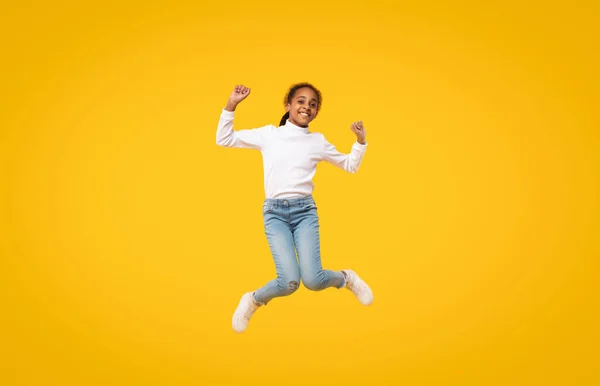 Overjoyed African American Little Girl Jumping Having Fun Posing Mid — Stok fotoğraf