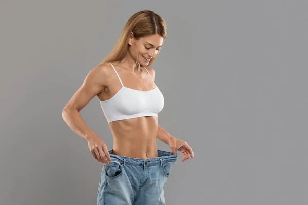 Happy Young Slim Female Wearing Big Oversize Jeans Posing Isolated — Stockfoto
