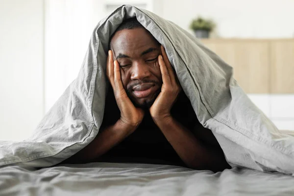 Sleepy Black Guy Covered Blanket Lying Suffering Sleeplessness Touching Face — 图库照片