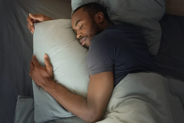 Top View African American Man Sleeping Embracing Pillow Lying Bed —  Fotos de Stock